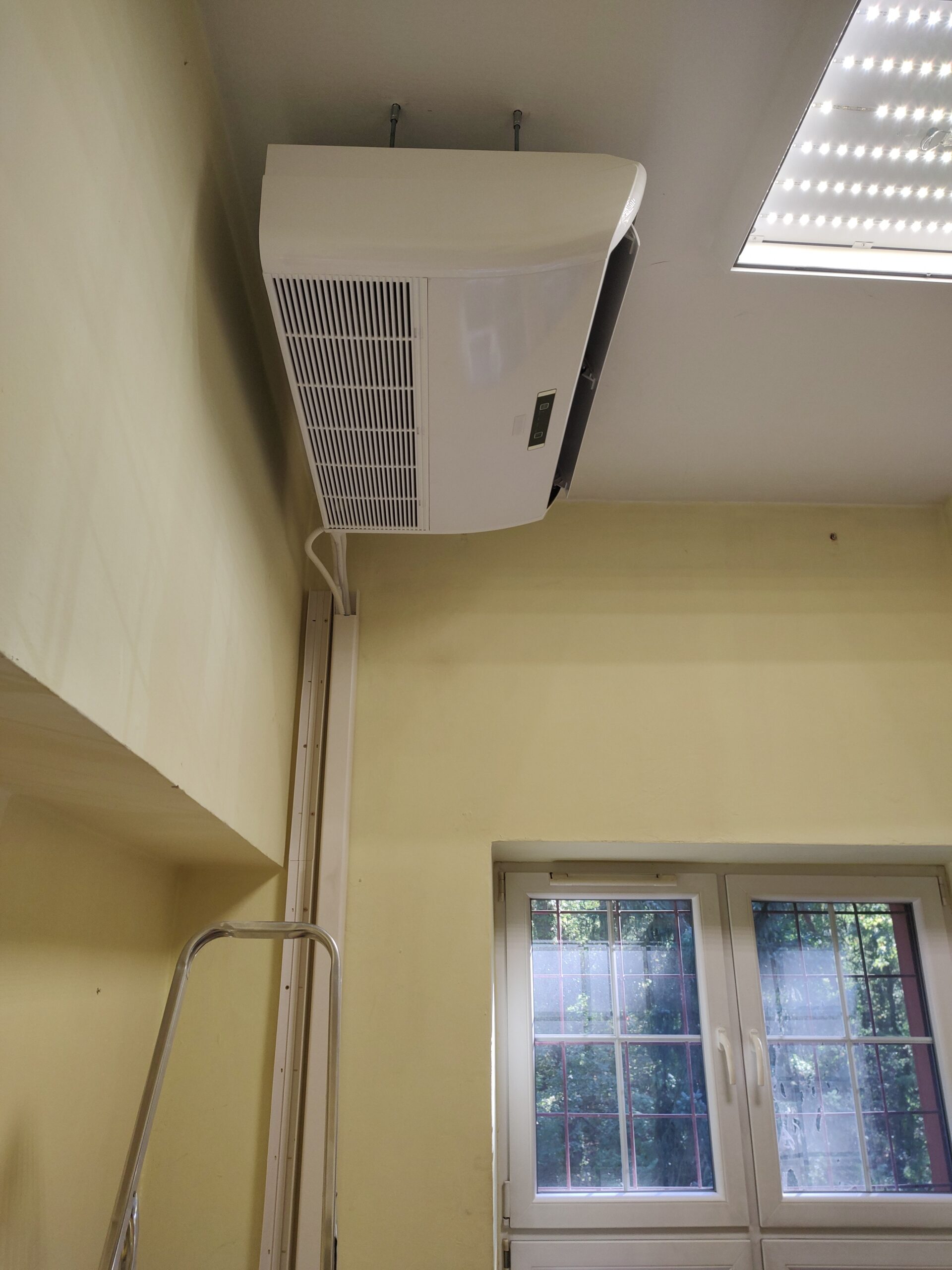 Instalacja klimatyzatora typu split w pokoju – jednostka wewnętrzna przy suficie